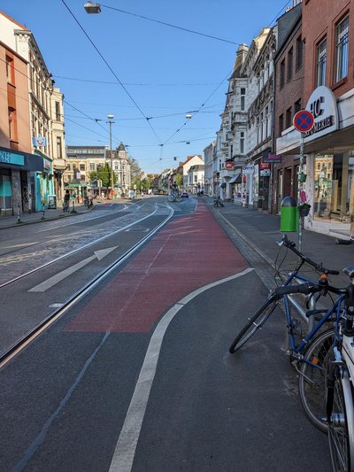 Rot markierter Radweg neben Straßenbahnschienen